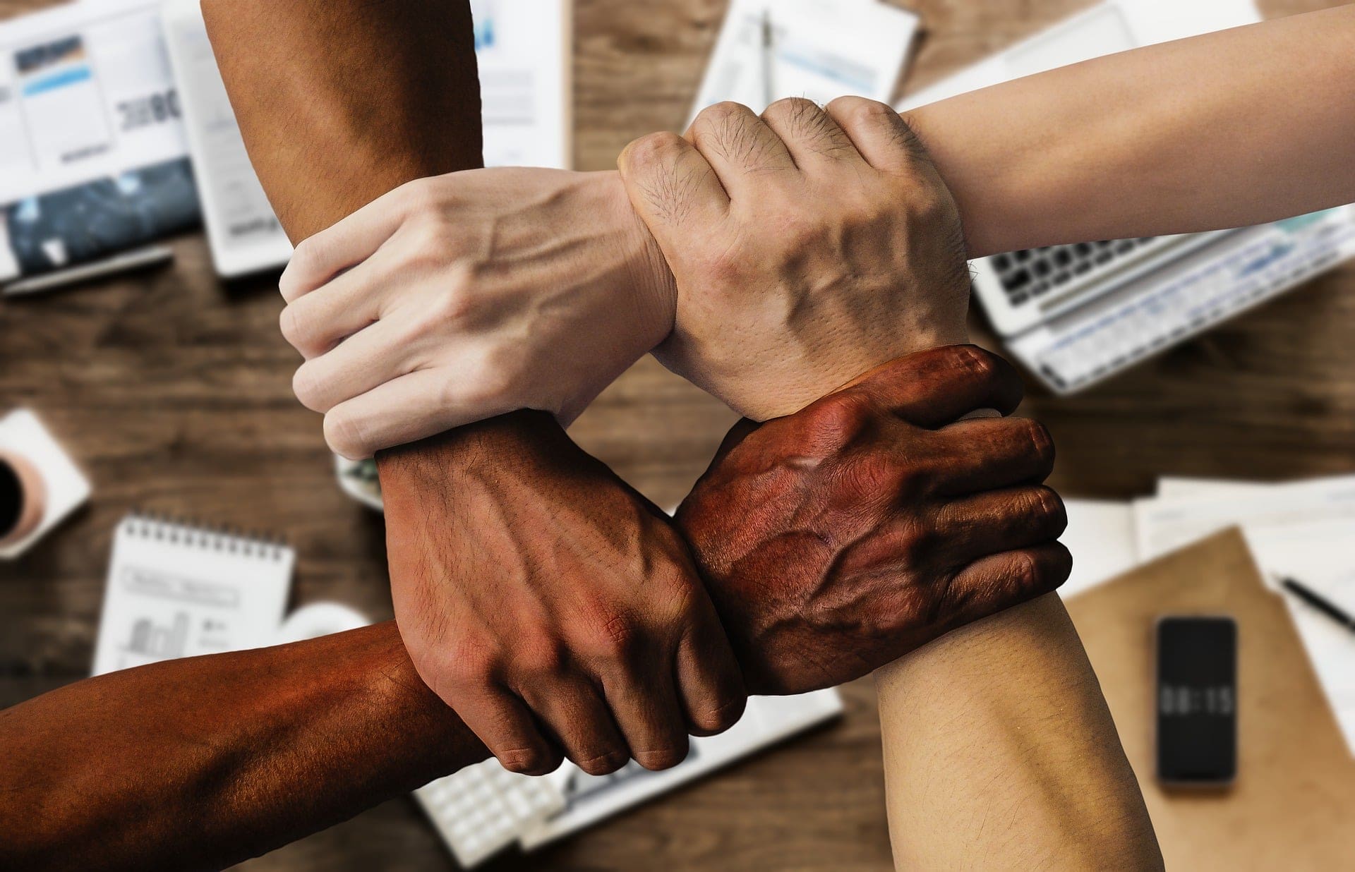 Photo of team hands holding arms by Tumisu for Pixabay