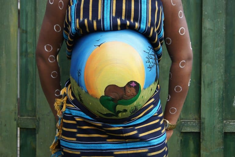 Photo of pregnant woman with belly painted by AnoukvanMarsbergen for Pixabay